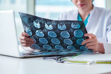 Ärztin hält MRI Bild in den Händen